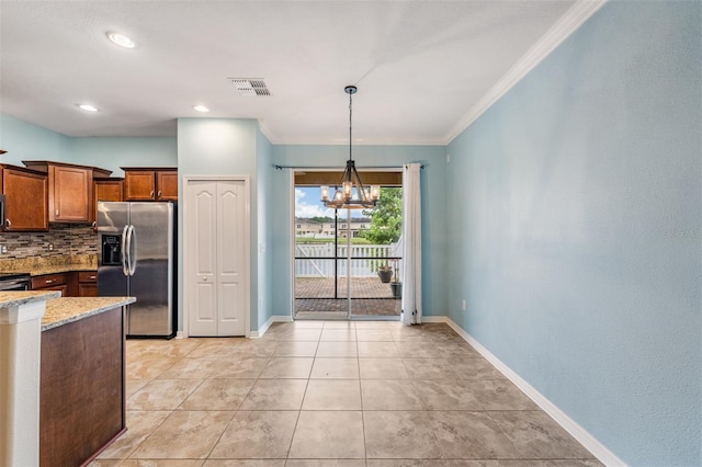 12039 Greengate Dr, Hudson, FL 34669 - kitchen featuring stainless steel appliances, a chandelier, light stone countertops, crown molding, and backsplash