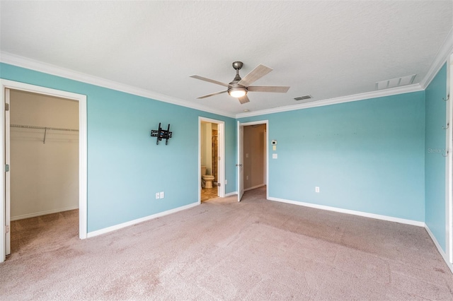 12039 Greengate Dr, Hudson, FL 34669 - unfurnished bedroom featuring crown molding, a spacious closet, carpet flooring, a closet, and ceiling fan