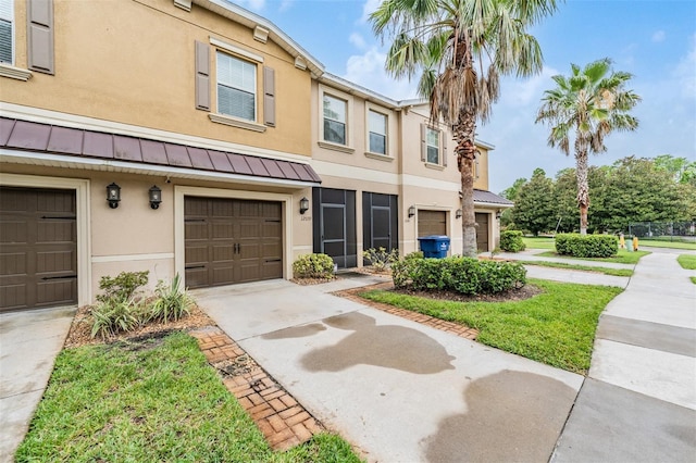 12039 Greengate Dr, Hudson, FL 34669 - multi unit property with a standing seam roof, stucco siding, concrete driveway, a garage, and a metal roof