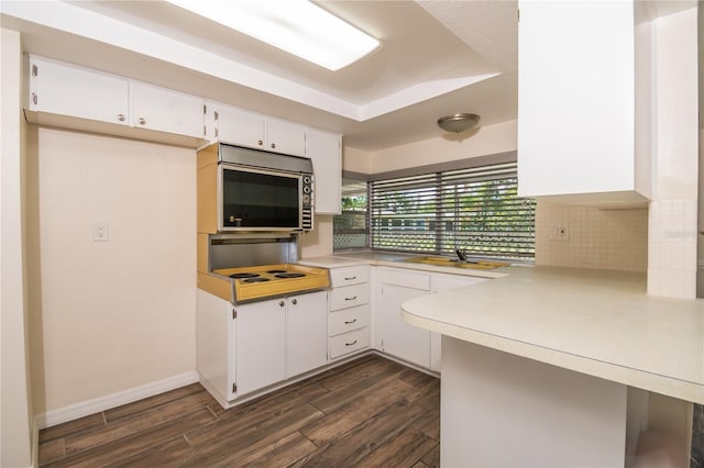 3406 Rock Royal Dr, Holiday, FL 34691 - kitchen featuring stainless steel microwave, tasteful backsplash, light countertops, and dark wood finished floors
