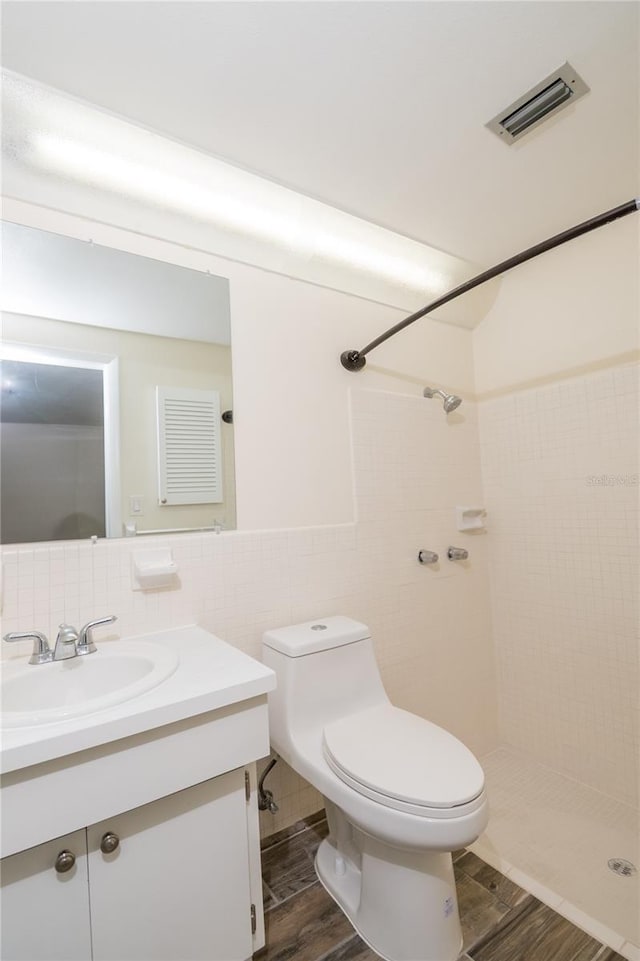 3406 Rock Royal Dr, Holiday, FL 34691 - full bath with vanity, wood finished floors, tile walls, and a tile shower