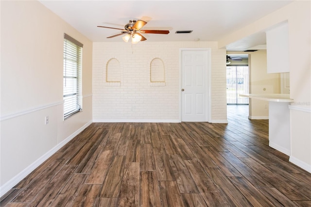 3406 Rock Royal Dr, Holiday, FL 34691 - unfurnished room with a ceiling fan, dark wood-style flooring, and brick wall
