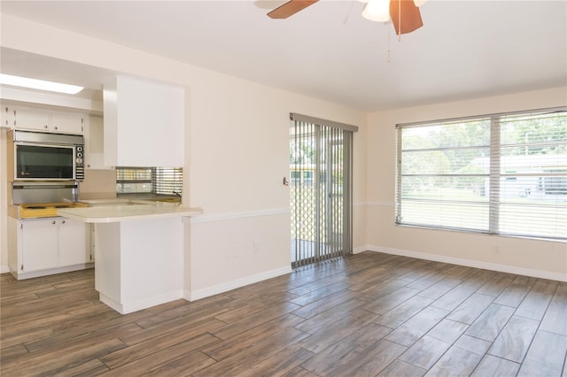 3406 Rock Royal Dr, Holiday, FL 34691 - kitchen with wood finished floors, stainless steel microwave, a ceiling fan, and healthy amount of natural light
