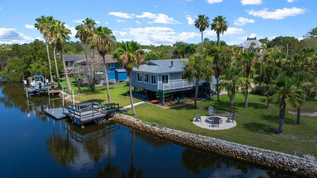 12046 W Gulf Breeze Ct, Crystal River, FL 34429 - dock featuring an outdoor fire pit, a water view, a lawn, and boat lift