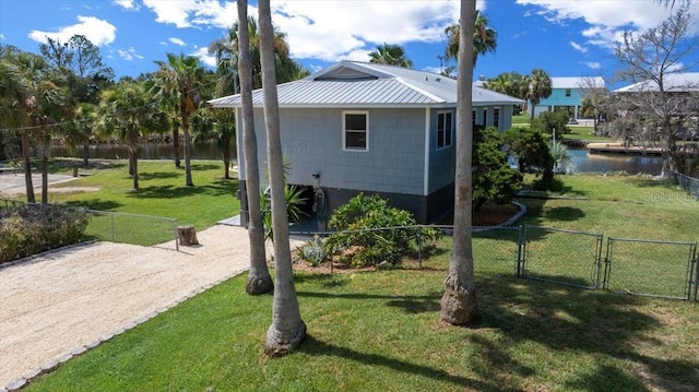 12046 W Gulf Breeze Ct, Crystal River, FL 34429 - view of property exterior featuring a gate, a water view, and a metal roof