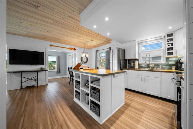 12046 W Gulf Breeze Ct, Crystal River, FL 34429 - kitchen with open shelves, freestanding refrigerator, white cabinetry, light wood finished floors, and wooden ceiling