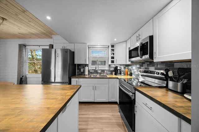 12046 W Gulf Breeze Ct, Crystal River, FL 34429 - kitchen featuring stainless steel appliances, wood counters, backsplash, light wood finished floors, and white cabinetry