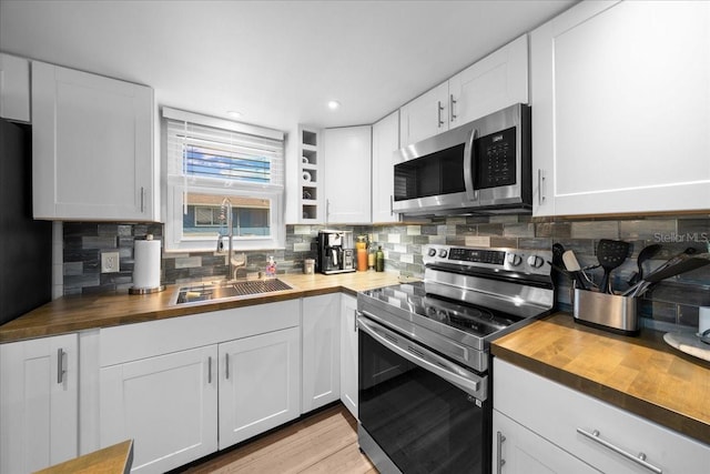 12046 W Gulf Breeze Ct, Crystal River, FL 34429 - kitchen with butcher block counters, appliances with stainless steel finishes, tasteful backsplash, white cabinetry, and recessed lighting