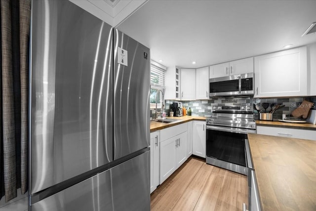 12046 W Gulf Breeze Ct, Crystal River, FL 34429 - kitchen featuring wooden counters, appliances with stainless steel finishes, light wood finished floors, white cabinets, and recessed lighting
