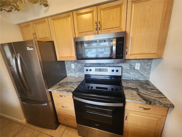 1975 W Bay Dr Unit 304, Largo, FL 33770 - kitchen with appliances with stainless steel finishes, decorative backsplash, dark stone counters, and light brown cabinets