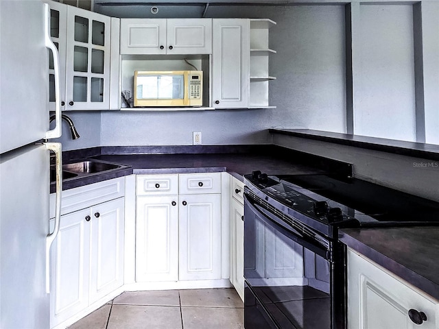 3315 58th Ave S Unit 409, Saint Petersburg, FL 33712 - kitchen with black / electric stove, freestanding refrigerator, dark countertops, and stainless steel microwave