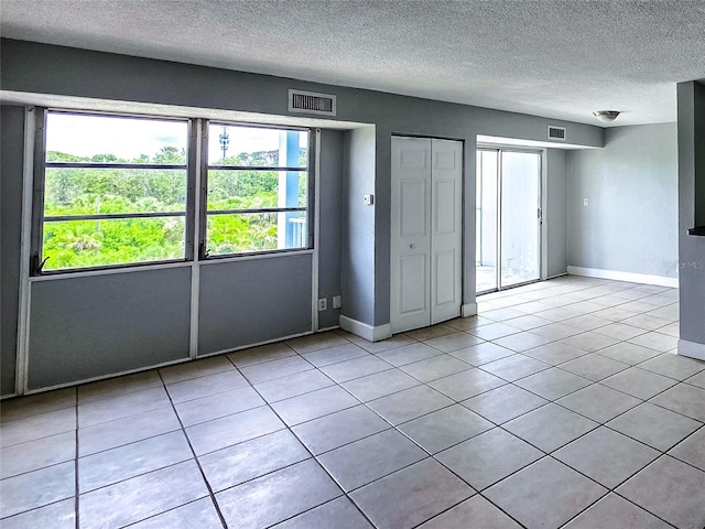 3315 58th Ave S Unit 409, Saint Petersburg, FL 33712 - empty room featuring a textured ceiling and light tile patterned floors