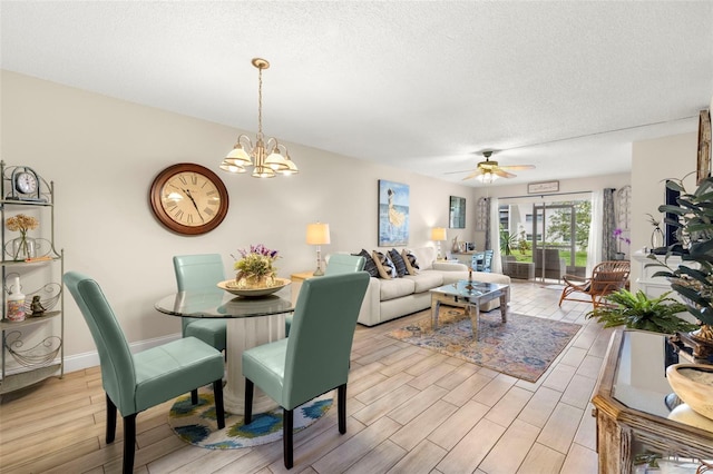1370 Heather Ridge Blvd Unit 105, Dunedin, FL 34698 - dining space with light wood-style flooring, a textured ceiling, a ceiling fan, and a chandelier
