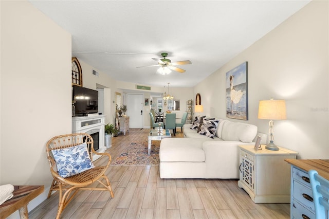 1370 Heather Ridge Blvd Unit 105, Dunedin, FL 34698 - living room with ceiling fan, light wood-type flooring, and a fireplace