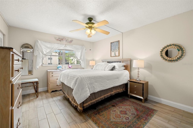 1370 Heather Ridge Blvd Unit 105, Dunedin, FL 34698 - bedroom featuring light wood finished floors, a textured ceiling, and ceiling fan