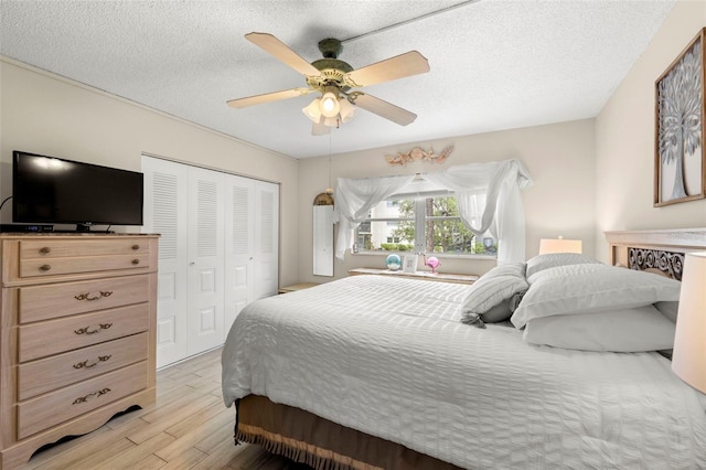 1370 Heather Ridge Blvd Unit 105, Dunedin, FL 34698 - bedroom with light wood-style floors, a closet, a ceiling fan, and a textured ceiling