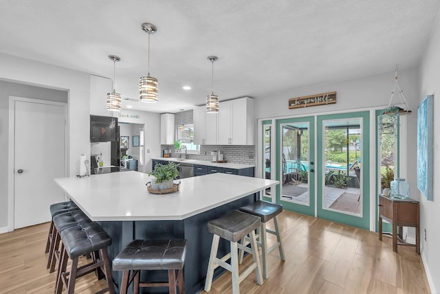 3731 Southview Dr, Brandon, FL 33511 - kitchen featuring a breakfast bar area, light countertops, white cabinetry, light wood-style floors, and recessed lighting