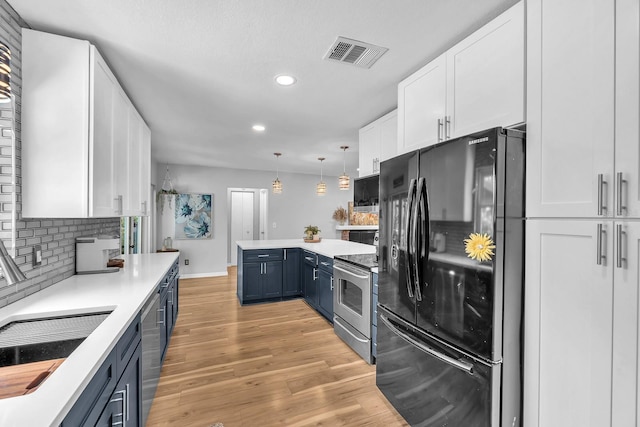 3731 Southview Dr, Brandon, FL 33511 - kitchen featuring appliances with stainless steel finishes, blue cabinets, white cabinets, recessed lighting, and light countertops