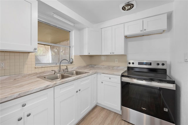 4923 Avery Rd, New Port Richey, FL 34652 - kitchen featuring stainless steel electric range oven, white cabinets, backsplash, and light wood-type flooring