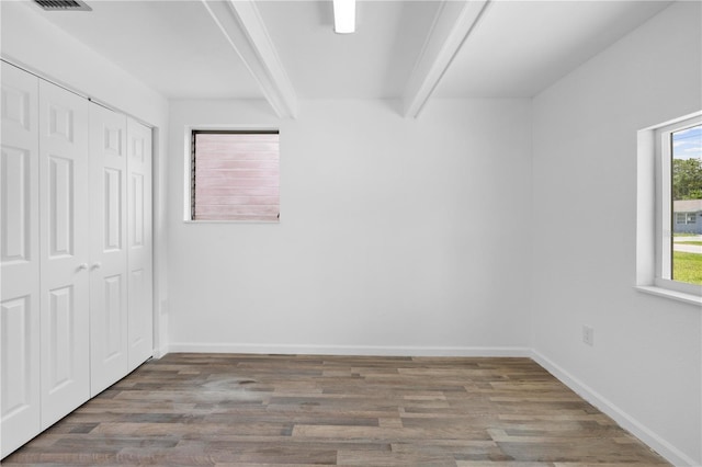 4923 Avery Rd, New Port Richey, FL 34652 - unfurnished bedroom with beam ceiling, wood finished floors, and a closet
