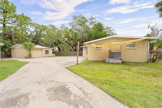 4923 Avery Rd, New Port Richey, FL 34652 - view of front of house featuring stucco siding, a detached garage, an outbuilding, and driveway