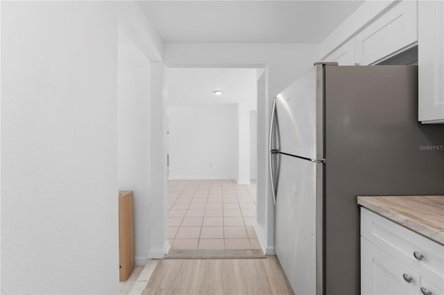 4923 Avery Rd, New Port Richey, FL 34652 - kitchen with freestanding refrigerator, white cabinets, light countertops, and light tile patterned floors