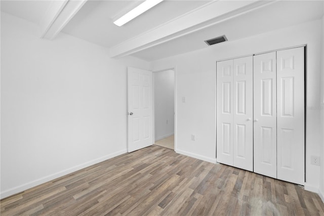 4923 Avery Rd, New Port Richey, FL 34652 - unfurnished bedroom with beamed ceiling, wood finished floors, and a closet