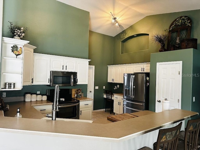 10080 SE 69th Ter, Belleview, FL 34420 - kitchen with stainless steel appliances, high vaulted ceiling, a peninsula, light tile patterned floors, and a kitchen bar