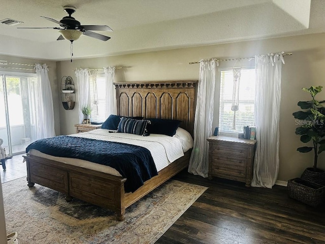 10080 SE 69th Ter, Belleview, FL 34420 - bedroom featuring multiple windows, access to outside, dark wood finished floors, and a ceiling fan