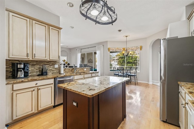 22623 Cliffside Way, Land O Lakes, FL 34639 - kitchen featuring stainless steel appliances, arched walkways, healthy amount of natural light, and light wood finished floors