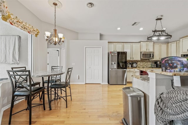 22623 Cliffside Way, Land O Lakes, FL 34639 - kitchen with stainless steel appliances, light wood-type flooring, decorative backsplash, recessed lighting, and hanging light fixtures