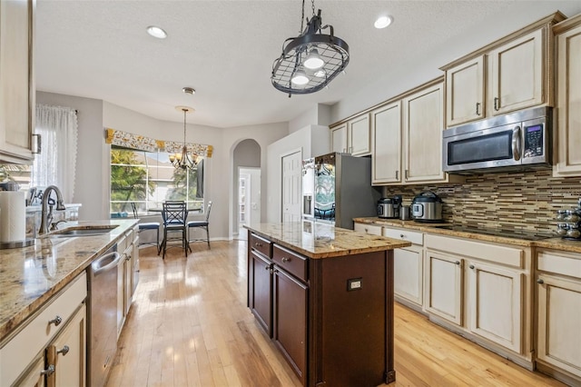 22623 Cliffside Way, Land O Lakes, FL 34639 - kitchen featuring stainless steel appliances, cream cabinets, backsplash, arched walkways, and recessed lighting
