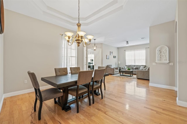 22623 Cliffside Way, Land O Lakes, FL 34639 - dining area featuring a chandelier, light wood-style flooring, and a raised ceiling