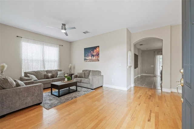22623 Cliffside Way, Land O Lakes, FL 34639 - living area featuring arched walkways, ceiling fan, light wood-type flooring, and plenty of natural light