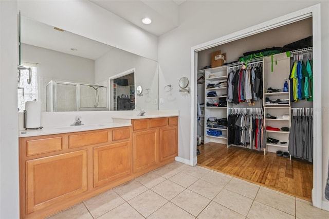 22623 Cliffside Way, Land O Lakes, FL 34639 - bathroom featuring tile patterned floors, double vanity, a shower stall, a spacious closet, and recessed lighting