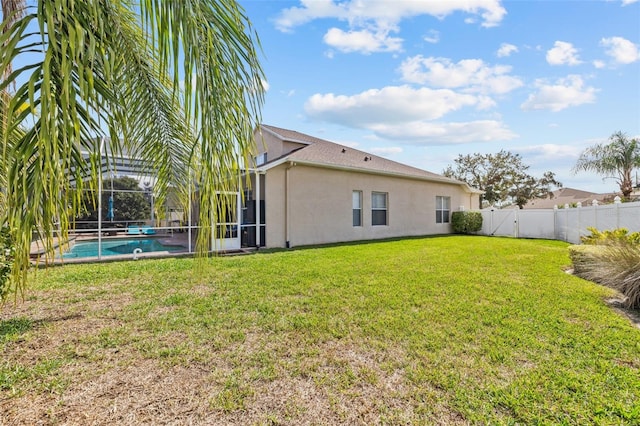 22623 Cliffside Way, Land O Lakes, FL 34639 - rear view of property with stucco siding, a fenced backyard, and glass enclosure