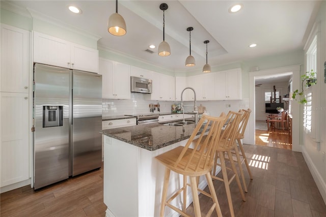 1407 S Moody Ave, Tampa, FL 33629 - kitchen featuring stainless steel appliances, white cabinets, decorative backsplash, a breakfast bar, and recessed lighting