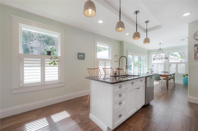 1407 S Moody Ave, Tampa, FL 33629 - kitchen featuring stainless steel dishwasher, dark stone countertops, pendant lighting, dark wood-style floors, and white cabinetry