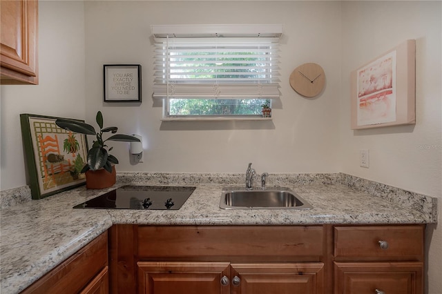1407 S Moody Ave, Tampa, FL 33629 - kitchen with black electric cooktop, brown cabinets, and light stone counters