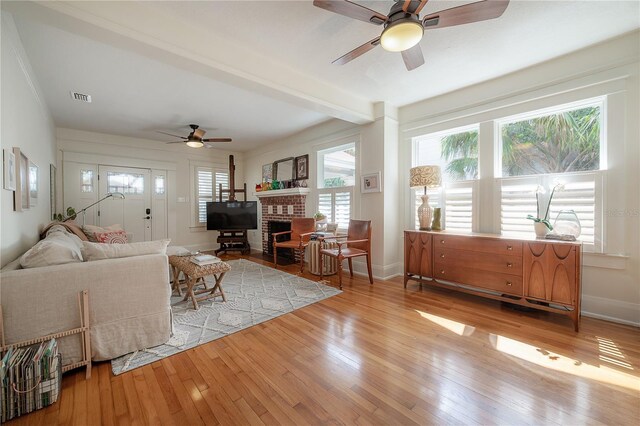 1407 S Moody Ave, Tampa, FL 33629 - living area with a ceiling fan, light wood-style flooring, beamed ceiling, and a brick fireplace