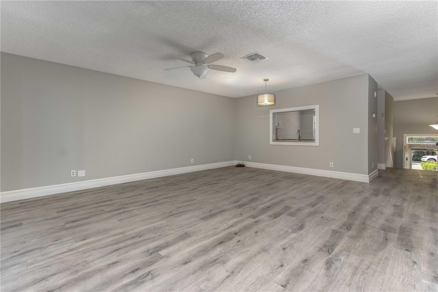 4117 Daventry Ln, Palm Harbor, FL 34685 - unfurnished room featuring ceiling fan, wood finished floors, and a textured ceiling
