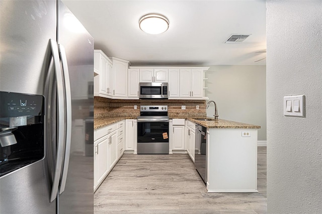 4117 Daventry Ln, Palm Harbor, FL 34685 - kitchen with appliances with stainless steel finishes, a peninsula, tasteful backsplash, stone countertops, and a textured wall