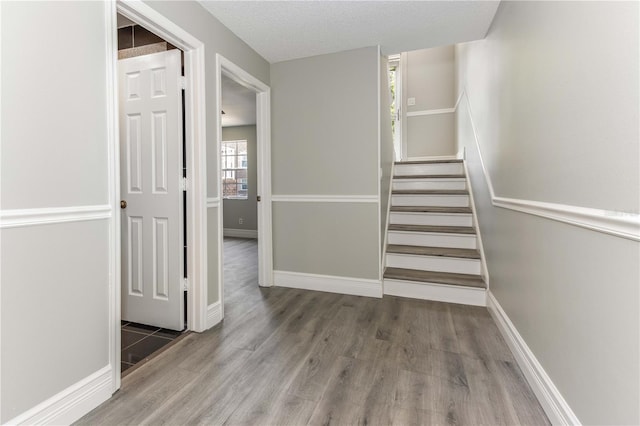 4117 Daventry Ln, Palm Harbor, FL 34685 - stairs featuring wood finished floors and a textured ceiling