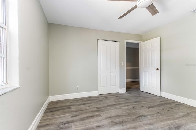 4117 Daventry Ln, Palm Harbor, FL 34685 - unfurnished bedroom with a closet, wood finished floors, and ceiling fan