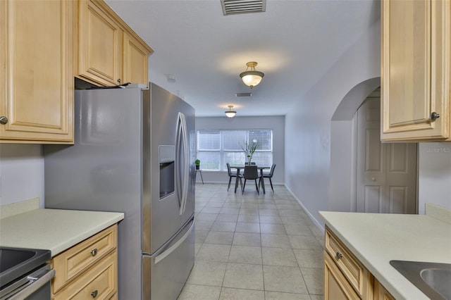 1708 Pond Lake Dr, Tampa, FL 33612 - kitchen with arched walkways, stainless steel refrigerator with ice dispenser, light countertops, light tile patterned flooring, and light brown cabinetry