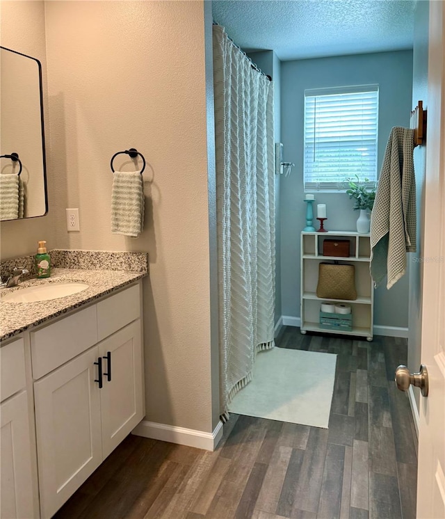 6270 Airmont Dr, Spring Hill, FL 34606 - full bathroom featuring wood finished floors, vanity, a shower with shower curtain, and a textured ceiling