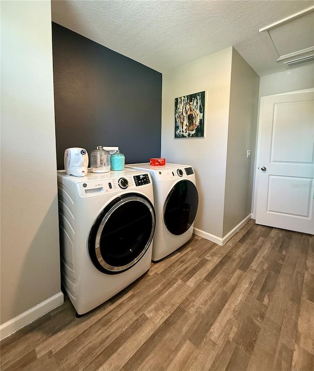 6270 Airmont Dr, Spring Hill, FL 34606 - laundry room with washer and clothes dryer, wood finished floors, attic access, and a textured ceiling