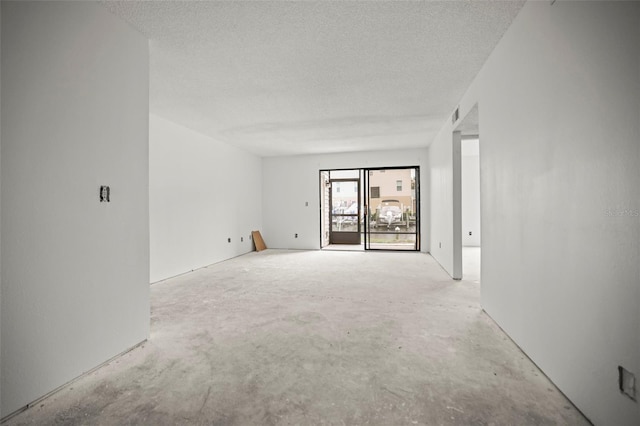 358 Moorings Cove Dr Unit 4B, Tarpon Springs, FL 34689 - spare room featuring unfinished concrete flooring and a textured ceiling
