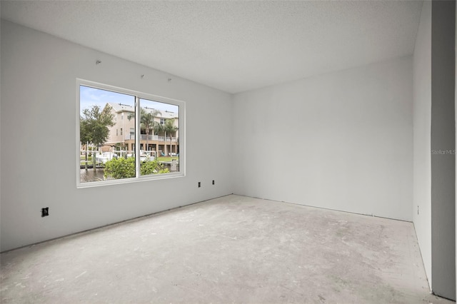 358 Moorings Cove Dr Unit 4B, Tarpon Springs, FL 34689 - spare room with a textured ceiling and unfinished concrete floors
