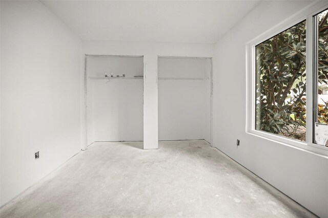 358 Moorings Cove Dr Unit 4B, Tarpon Springs, FL 34689 - unfurnished bedroom with concrete flooring and two closets